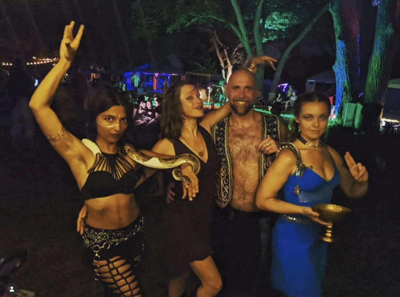 Belly dancers and a performer with a python at a night event