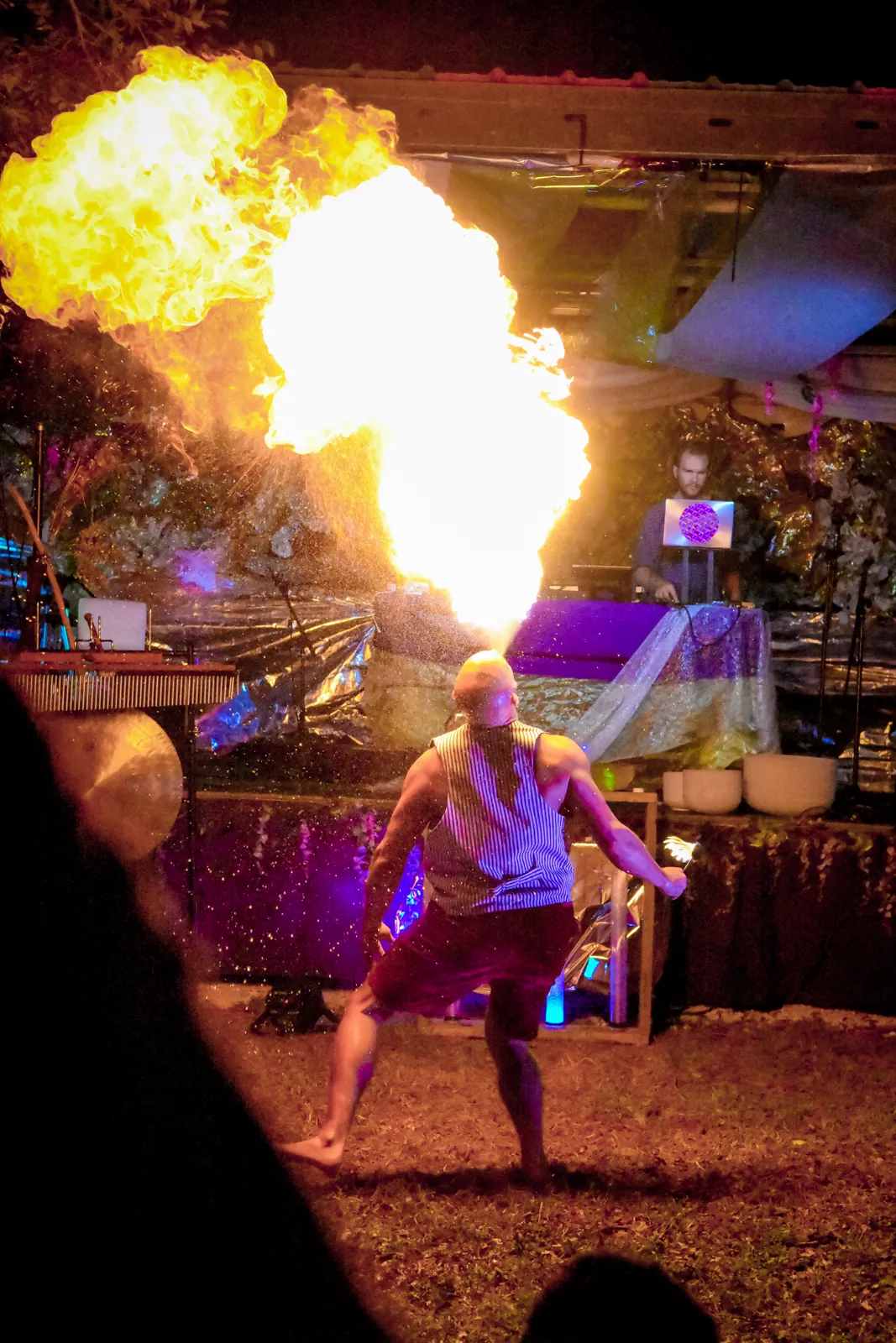 A Great Medicine Show fire breather sends a column of flame into the night sky at an outdoor show